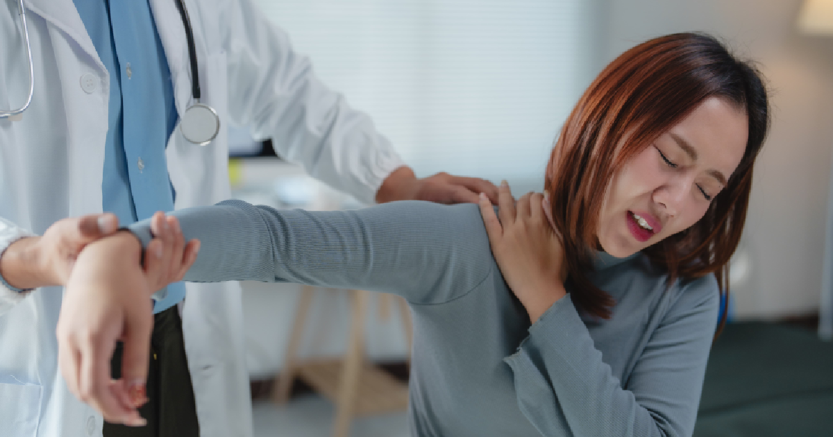 A doctor assists a woman experiencing shoulder pain during personalized pain management in Charlottesville, VA.