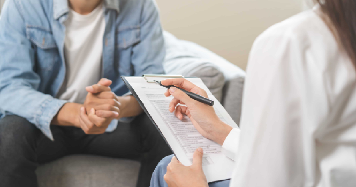 Professional reviewing a document with a client for Behavioral Health in Charlottesville, VA.